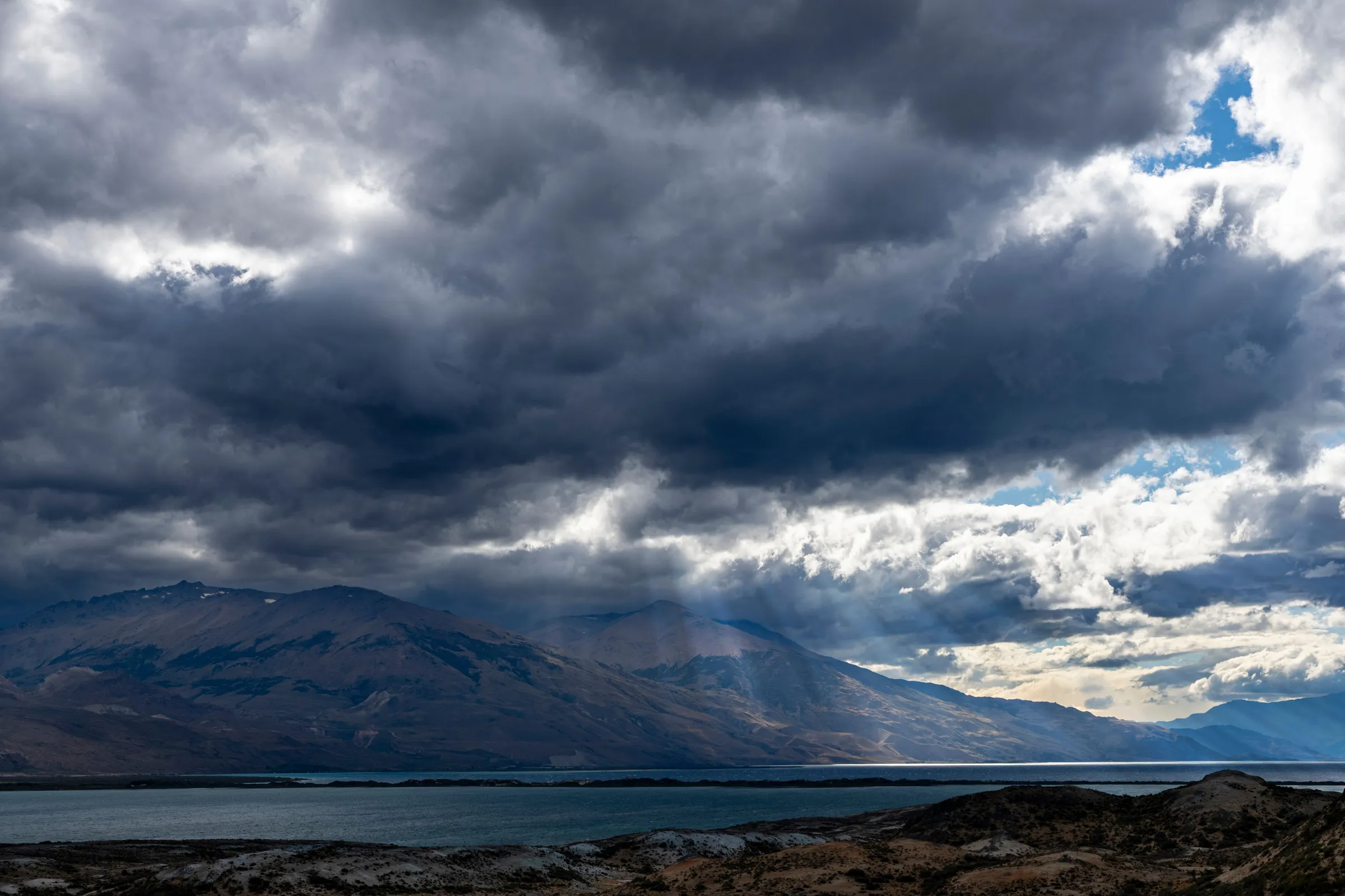 Heavy clouds and shifting light over Lago Posadas in Santa Cruz