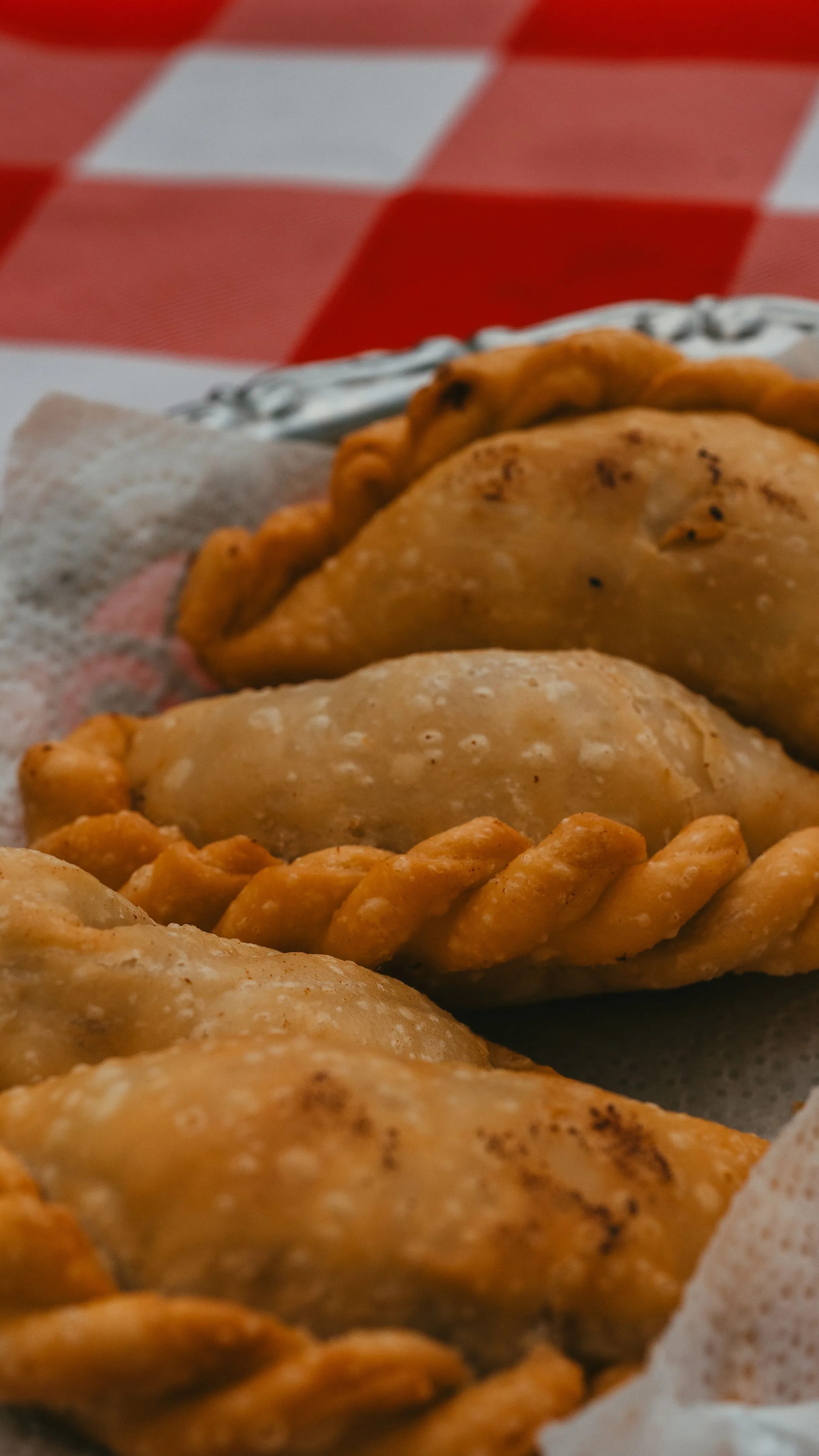 Golden empanadas on a checked cloth in Uribelarrea