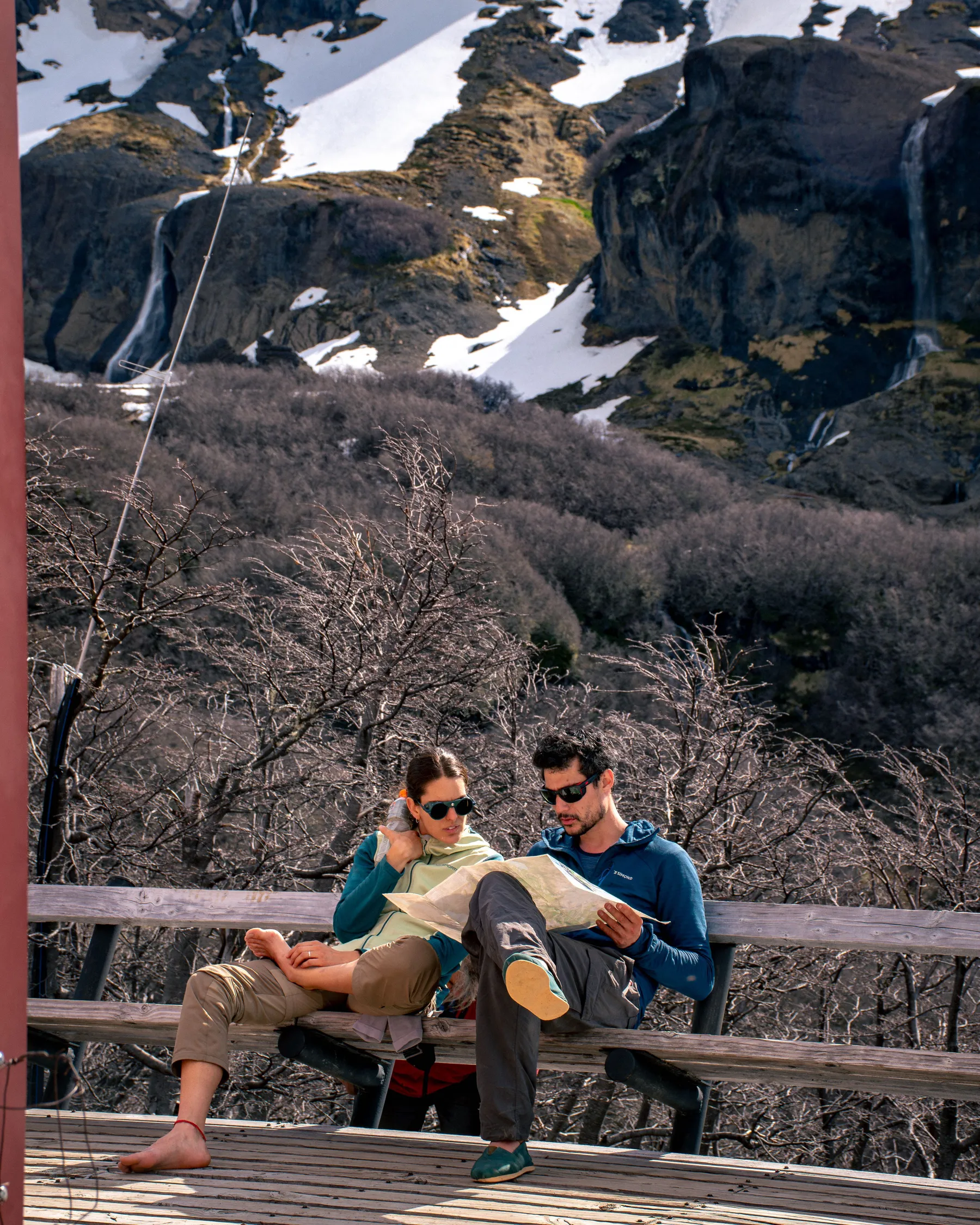 Walkers pausing with a map in Bariloche's mountain scenery.