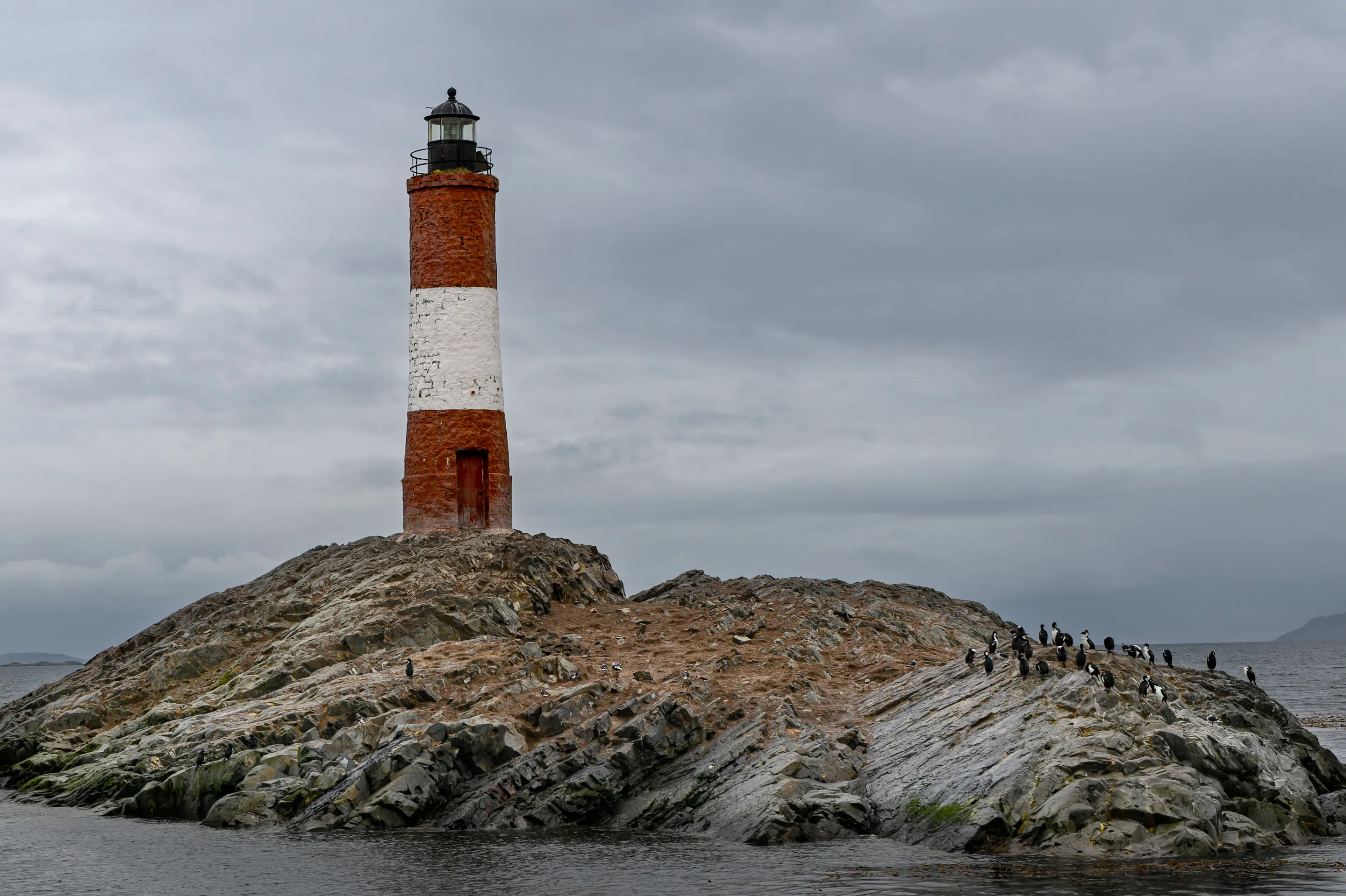 Les Éclaireurs lighthouse on its rocky island beneath clouds.