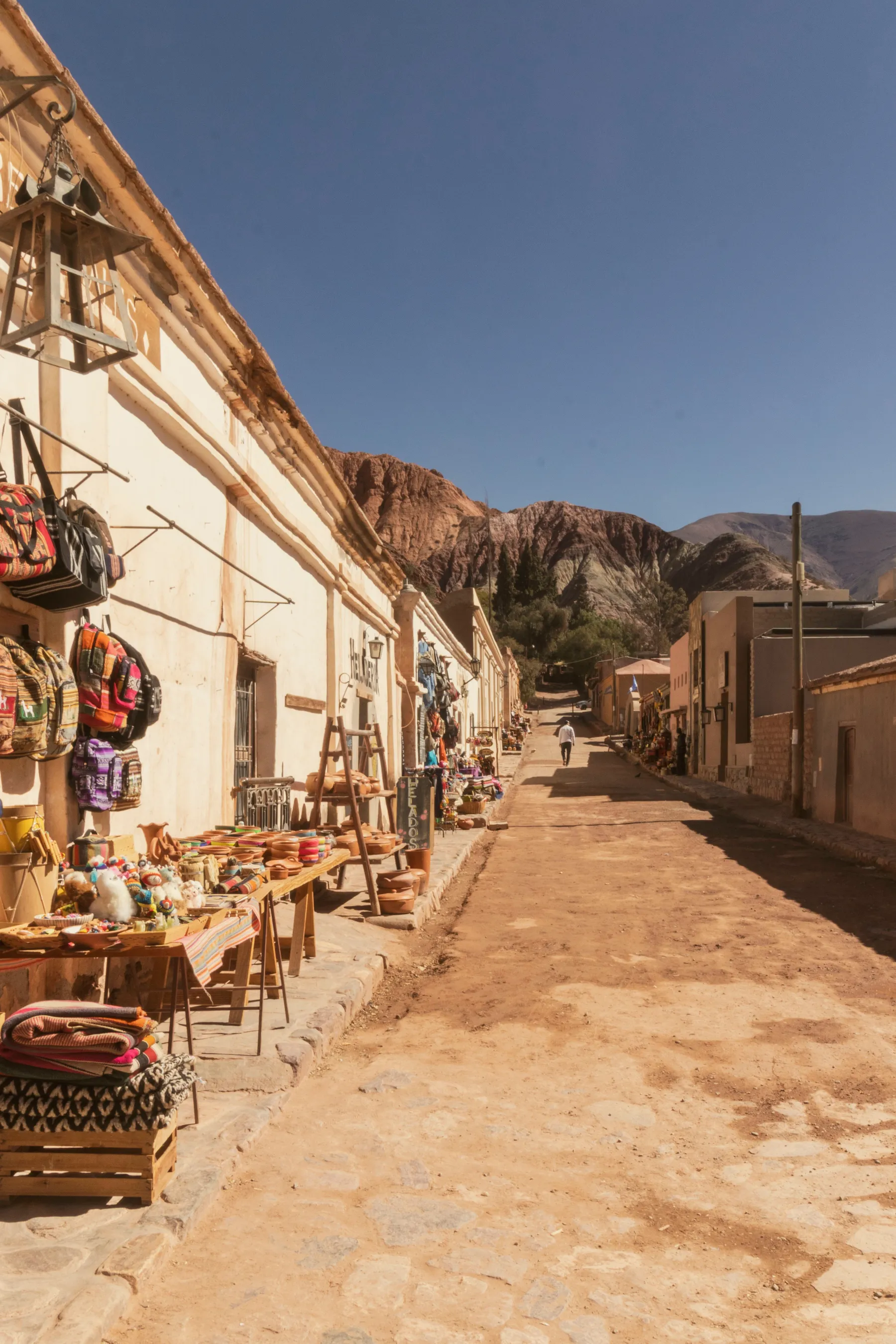 Market stalls and mountain scenery on a Purmamarca street.