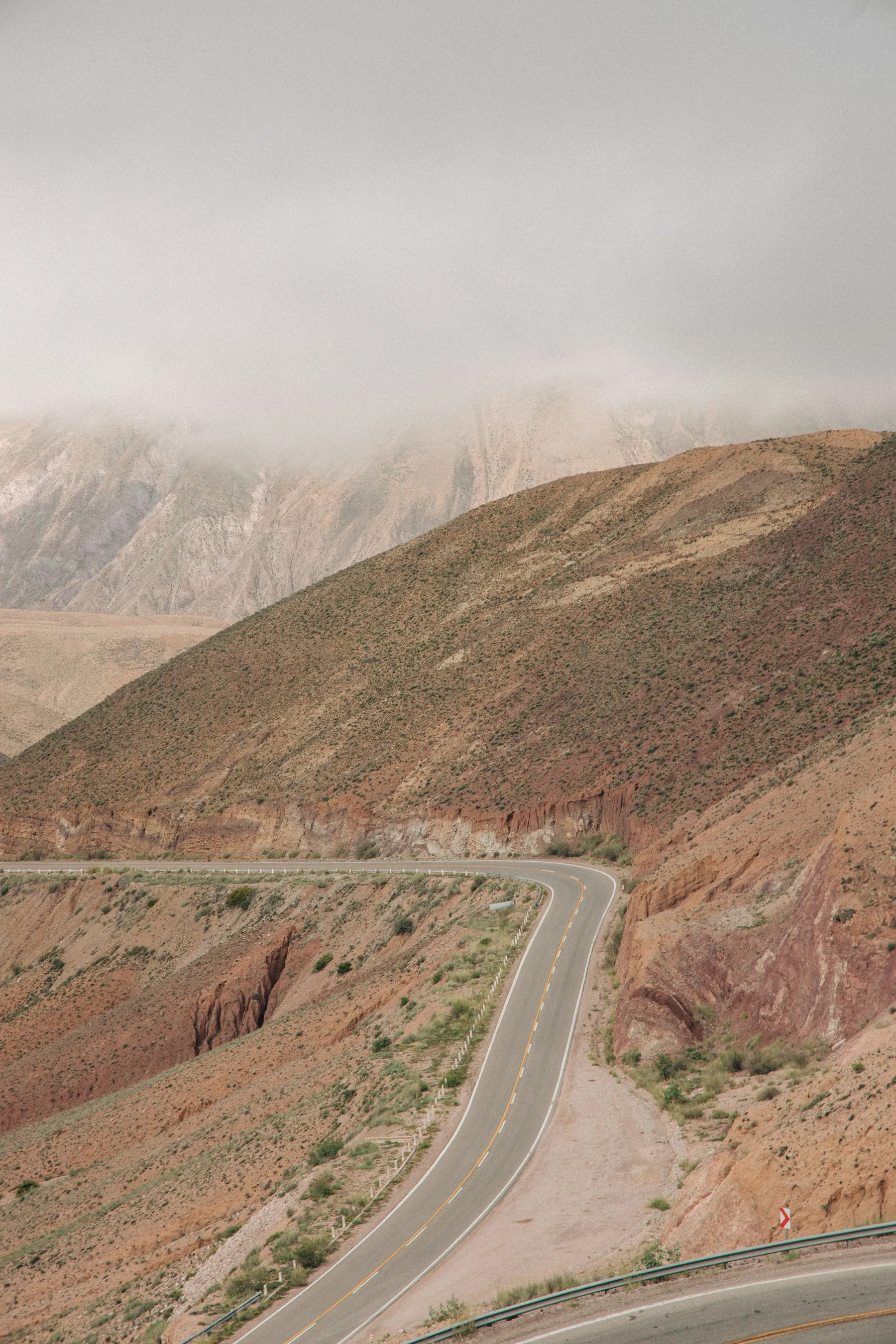 A curving mountain road above the Purmamarca area under cloud