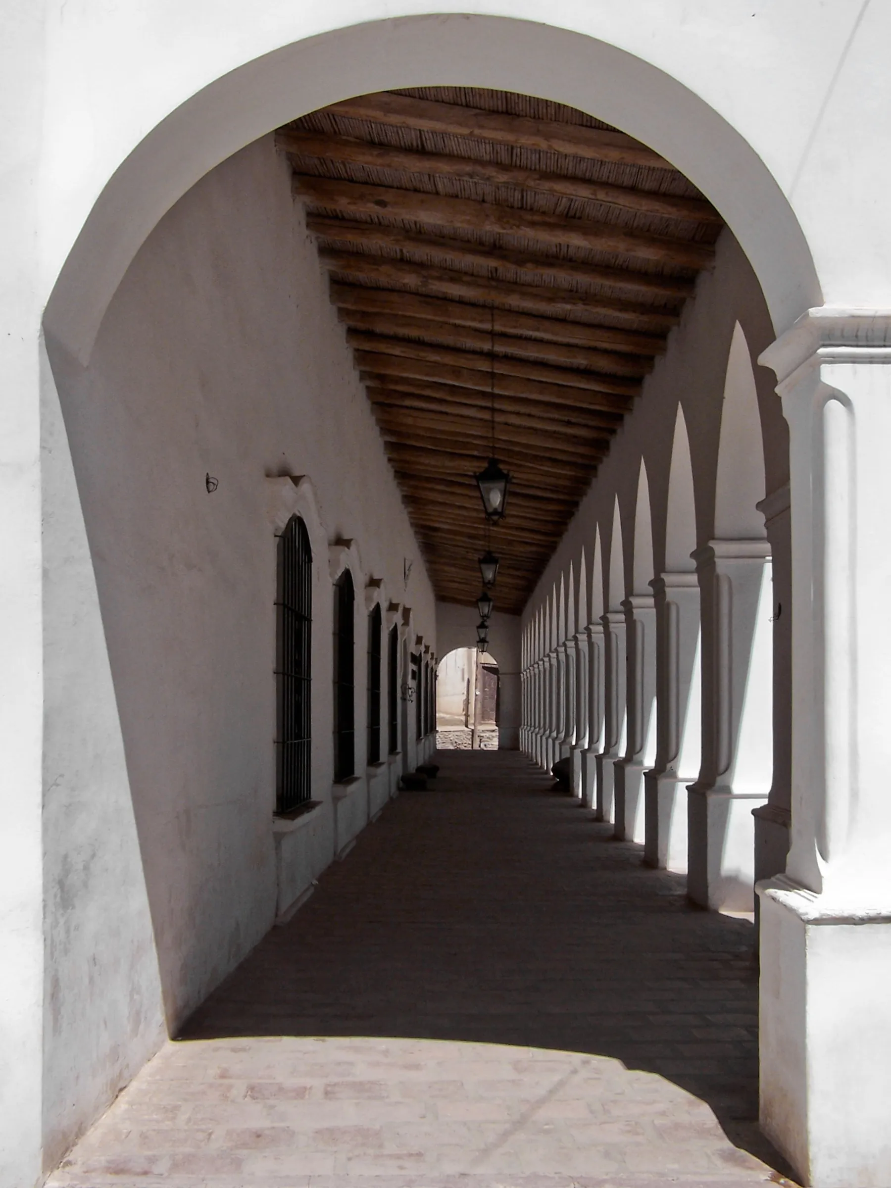 Sunlight and shadow along a whitewashed arcade in Cachi