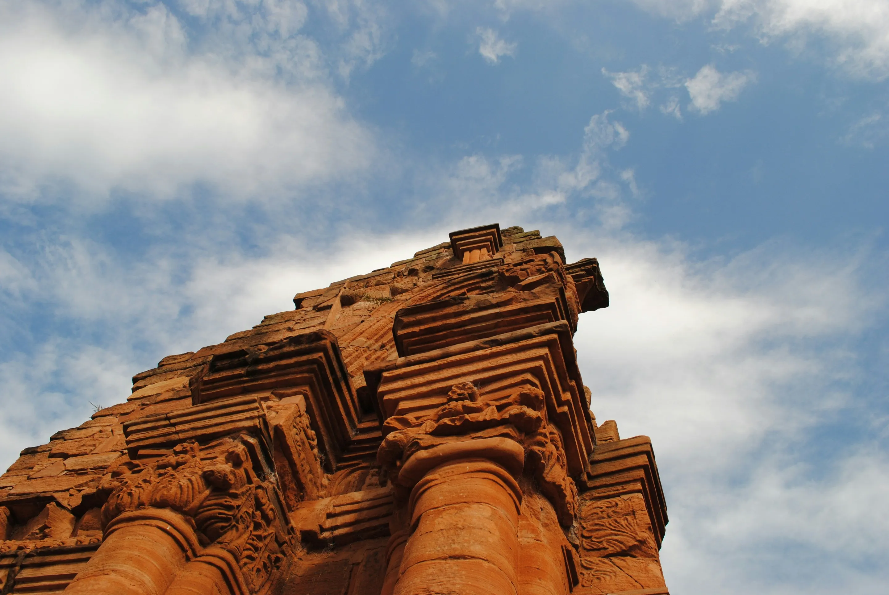 Carved red stone column and cornice against the sky at San Ignacio Miní