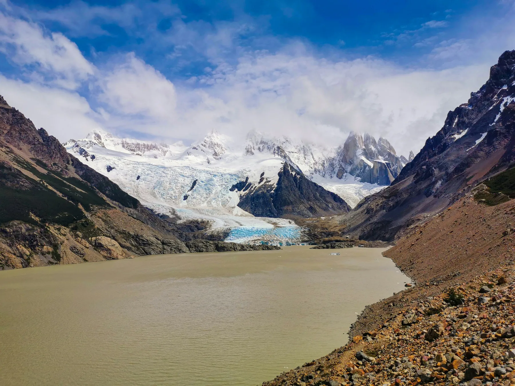 Laguna Torre surrounded by dark mountains and cloud