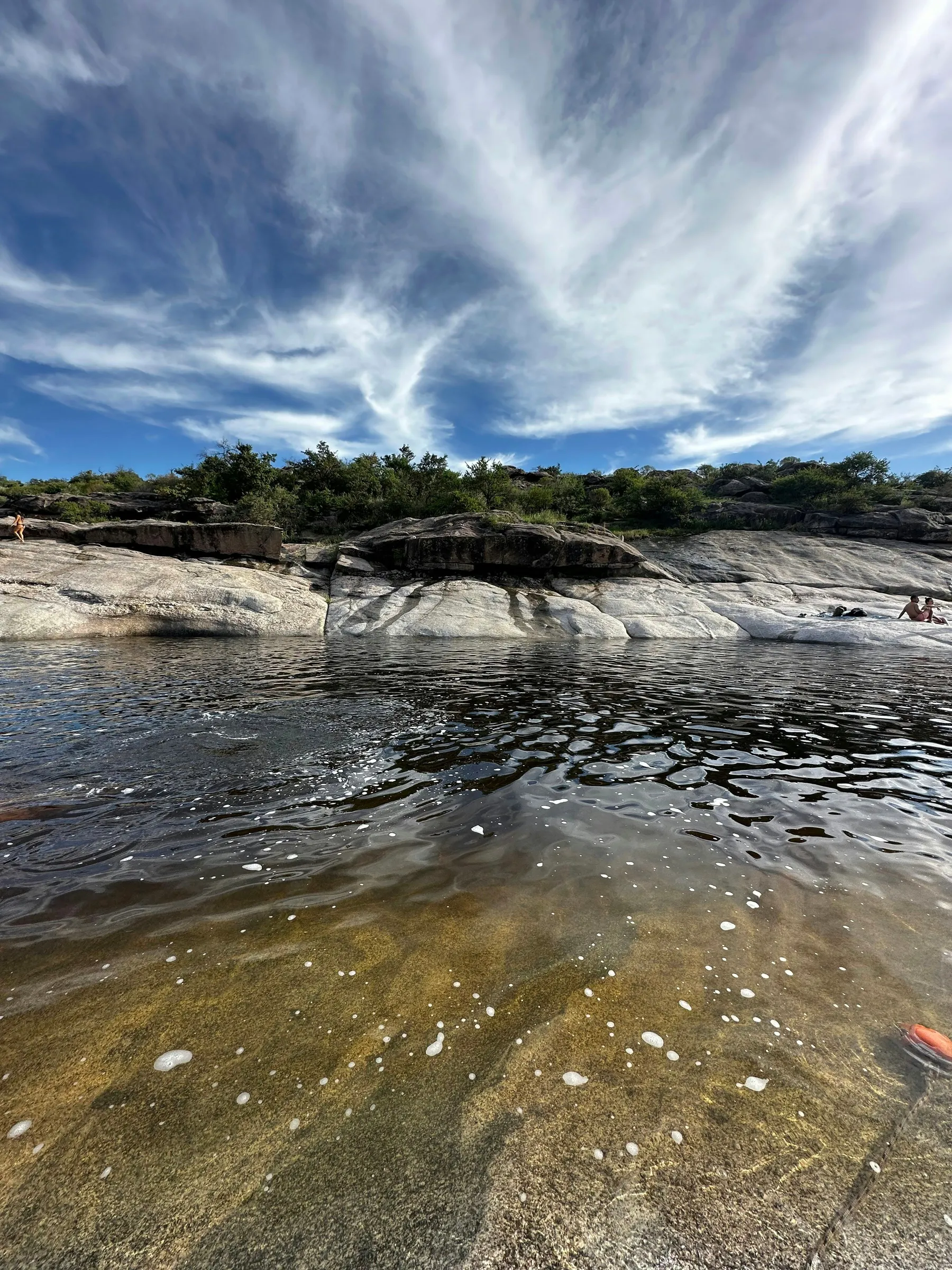Water and sculpted rock beneath sweeping clouds at La Toma