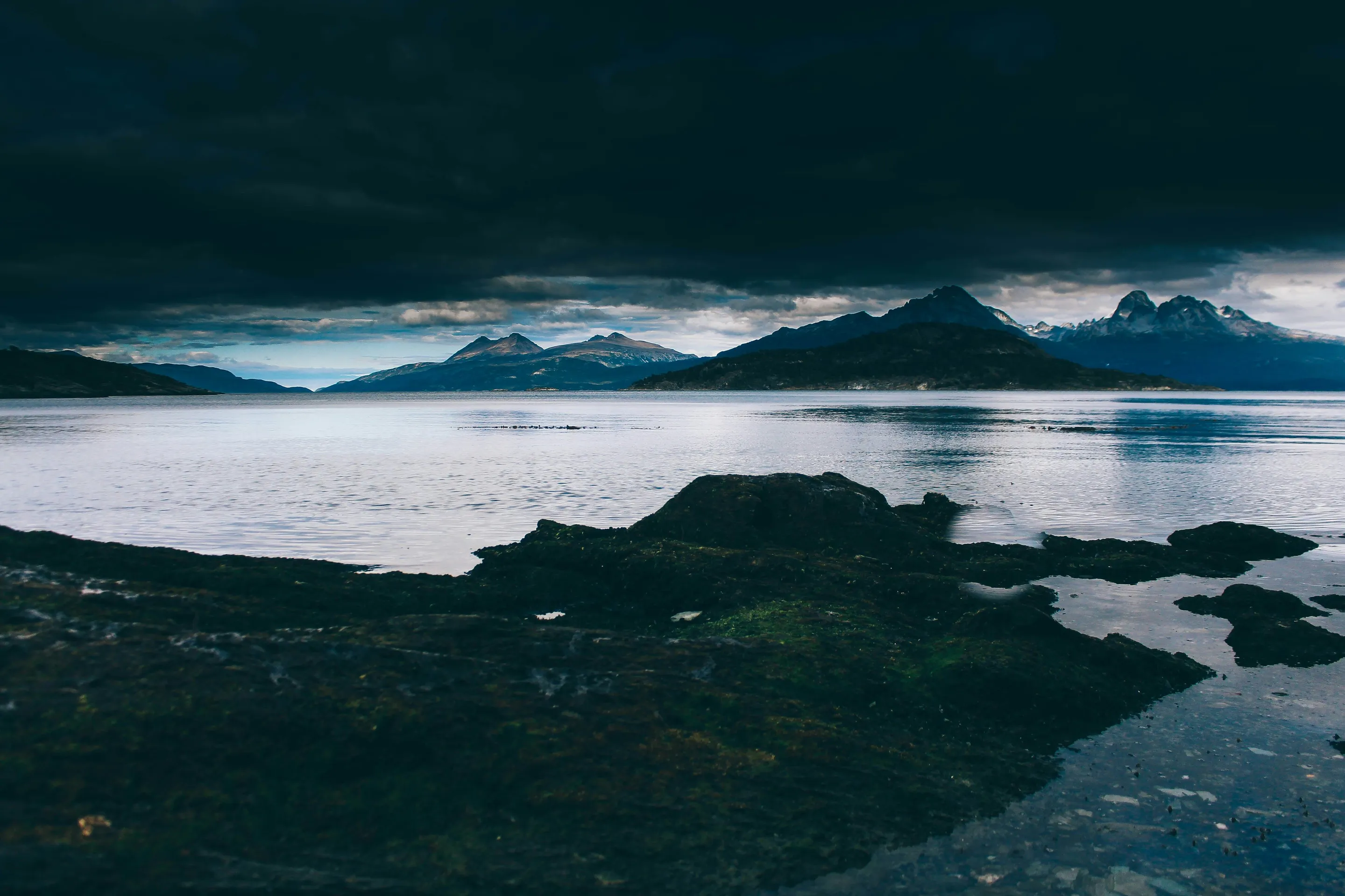 Dark clouds above water and mountains in Tierra del Fuego National Park.