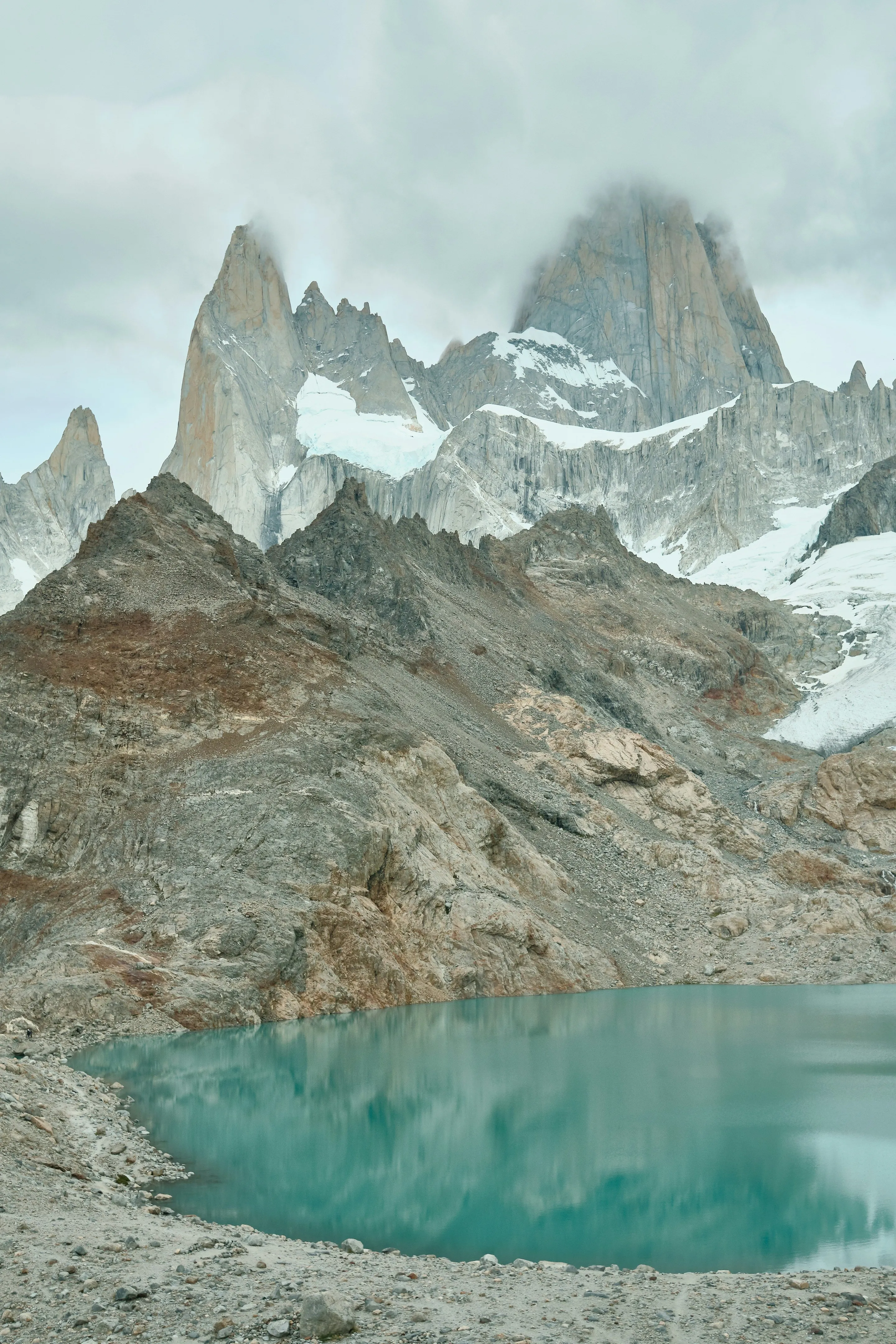 Turquoise Laguna de los Tres beneath jagged snow-covered peaks and cloud