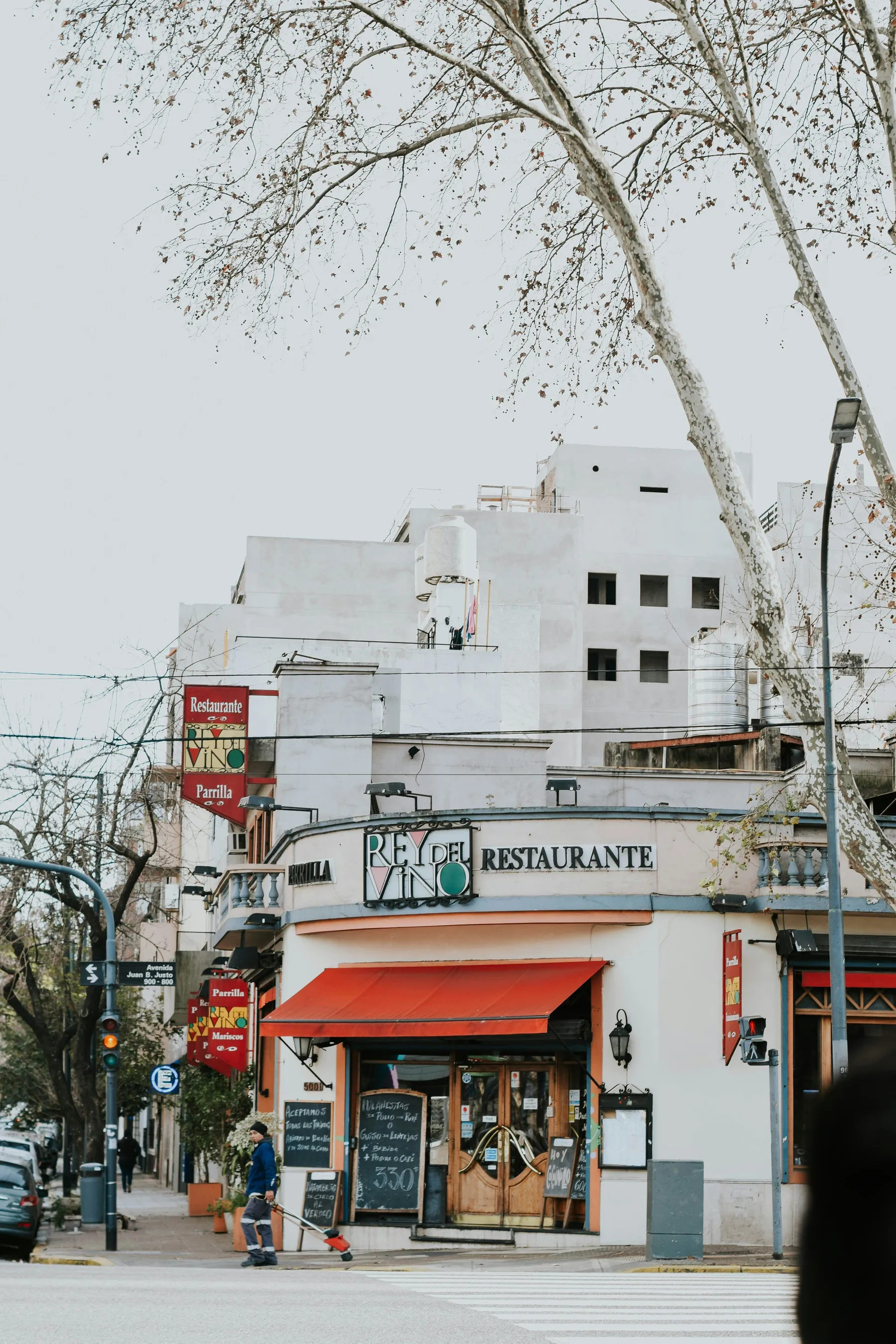 A corner restaurant façade with red awnings in Palermo Soho