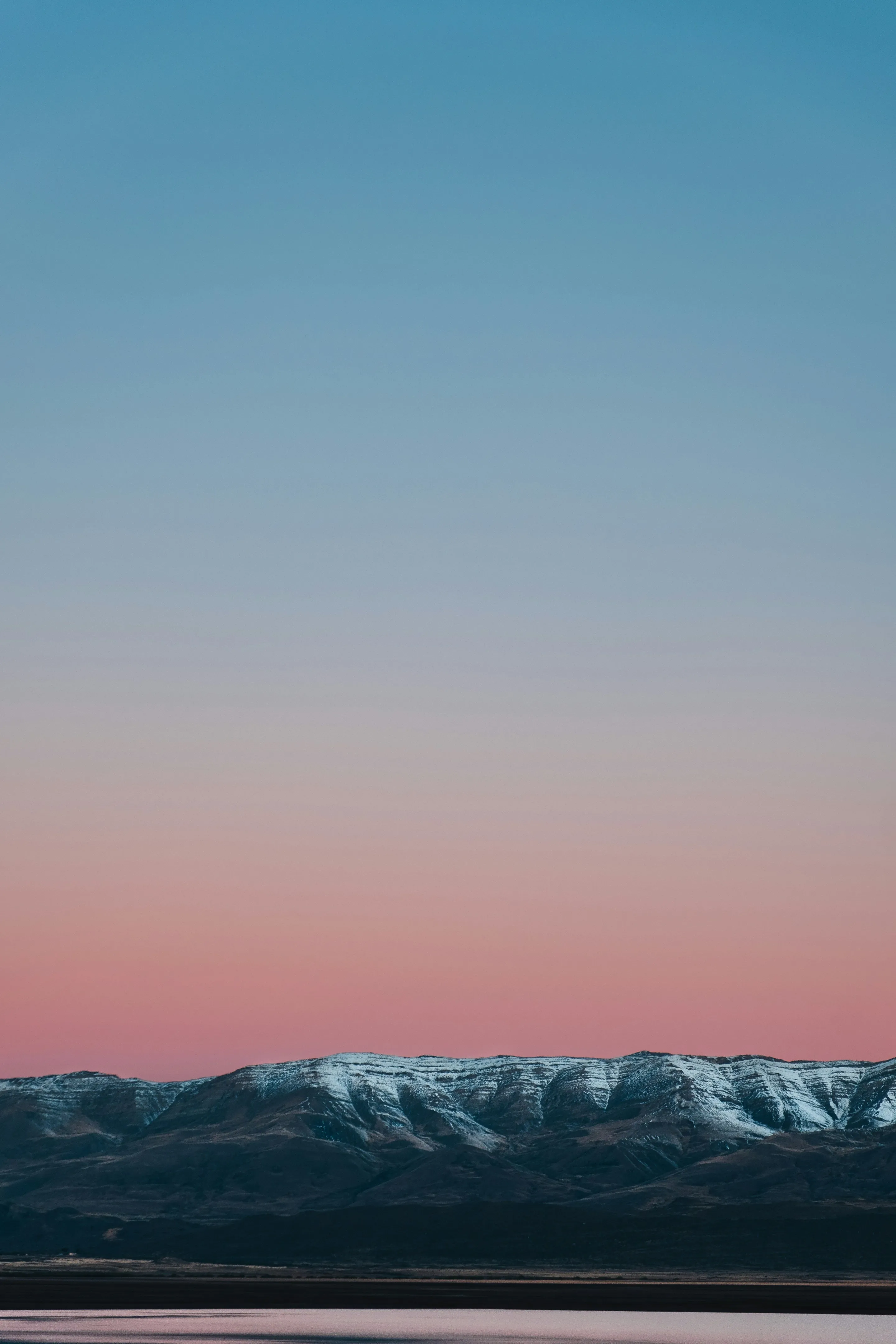 A snowy Patagonian mountain beneath richly coloured evening light.