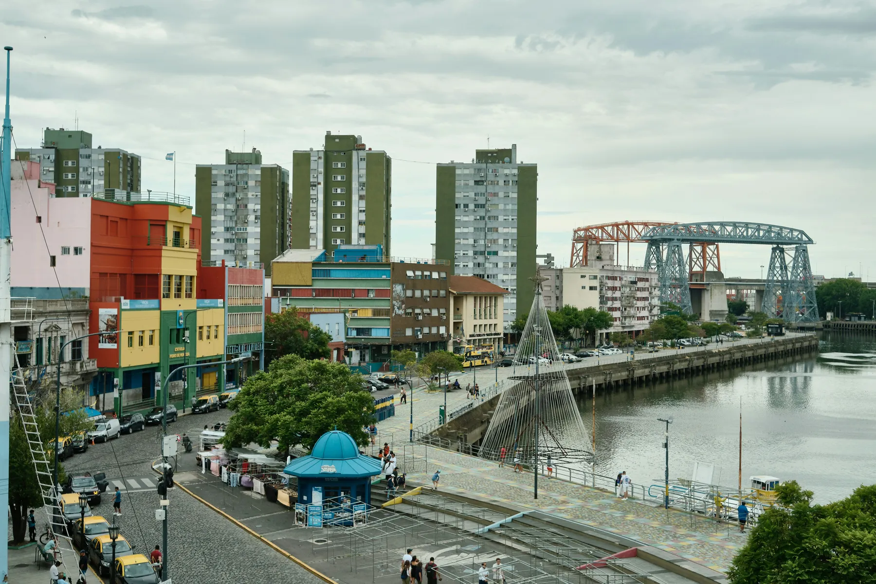 Painted waterfront buildings with the iron transporter bridge beyond in La Boca