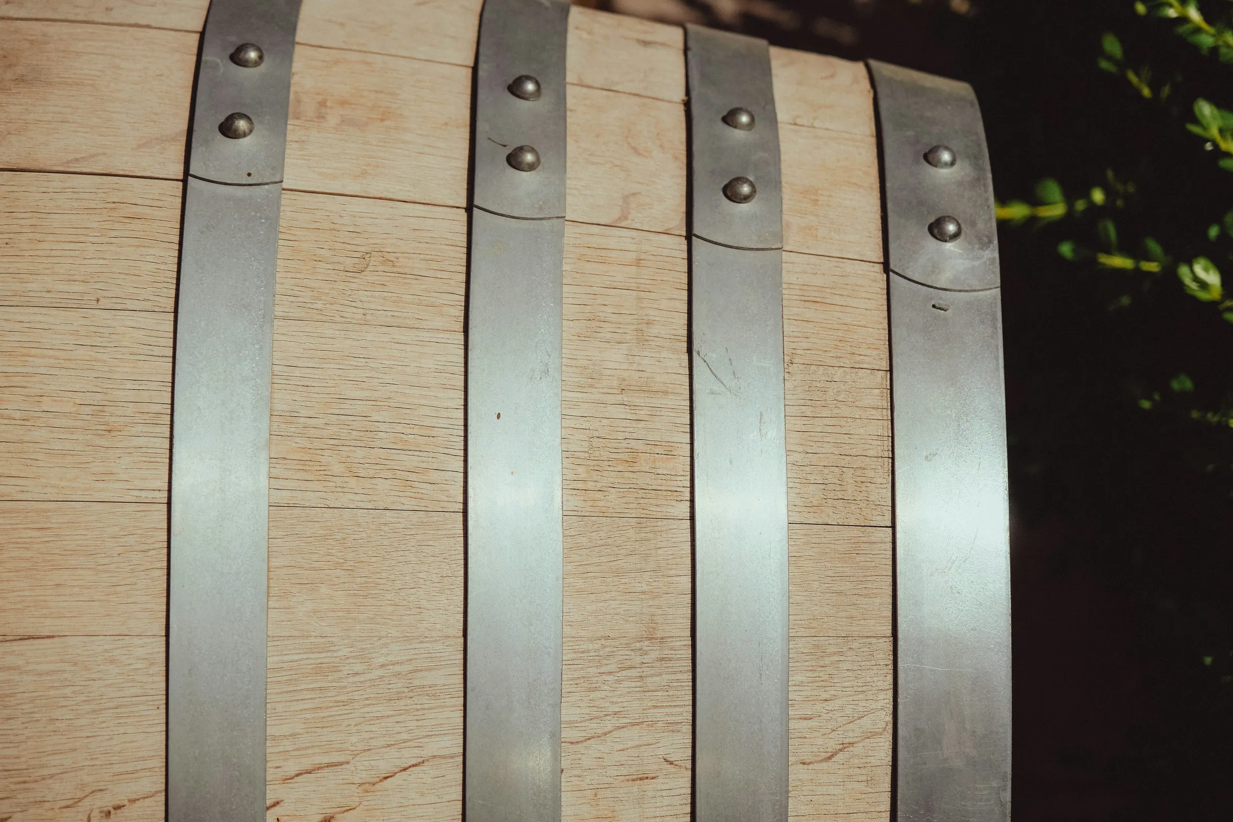 The texture of a wooden wine barrel and its metal bands.